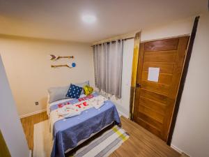 阿布拉奥Canoa Abraão的一间小卧室,配有一张床和一扇木门
