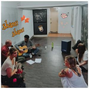 迈索尔Funky Buddha Hostel的一群坐在一个房间里弹吉他的人