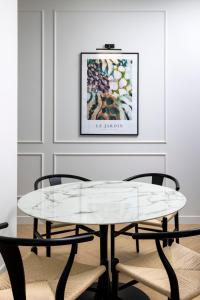 蒙特卡罗Secret Contemporary Courtyard的配有两把椅子的房间里一张玻璃桌