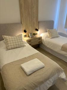 耶尔瓦布埃纳Casa Ceibo - Bon Repos的一间卧室配有两张床和一张带毛巾的桌子