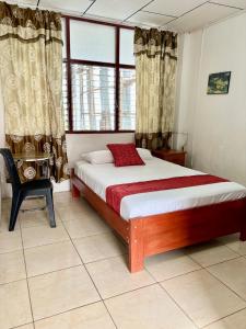 伊基托斯Hospedaje Casa Amazónica Iquitos的卧室配有床、椅子和窗户。