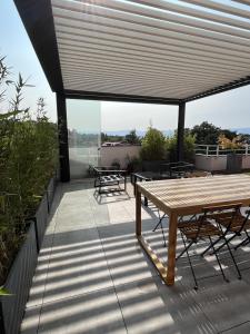 埃维昂莱班IMMODREAMS - L'Attik with lake views and 80m2 terrace的屋顶上带桌椅的天井
