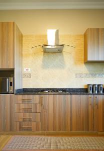 阿鲁沙Westwood Residences的厨房配有木制橱柜和炉灶烤箱。