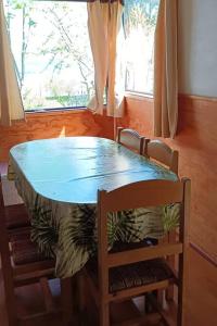 瓦尔迪维亚Cabaña a metros de la playa San Ignacio, Niebla的一张带两把椅子和一张蓝色桌子的餐桌