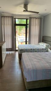 圣拉蒙MILANO SUITE的一间卧室设有两张床和大窗户