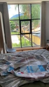 圣拉蒙MILANO SUITE的卧室内的一张床铺,设有大窗户