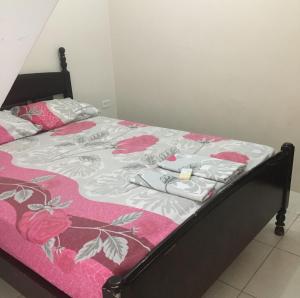 克鲁奇塔Casa Ballena的一张带粉红色和白色的棉被和粉红色玫瑰的床
