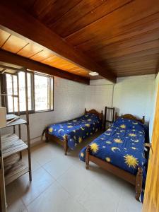 米娜克拉韦罗EL CHALÉ casa de campo的一间卧室设有两张床和木制天花板