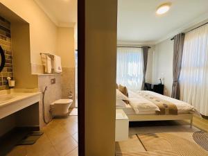 阿鲁沙Westwood Residences的一间卧室配有一张床,浴室设有水槽