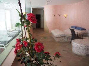 蒂罗尔-泽费尔德伊格特霍夫酒店的花瓶里装有红色花卉的客厅