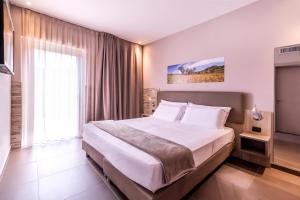 拉古萨San Giorgio Palace Hotel Ragusa Ibla的一间卧室设有一张大床和一个大窗户