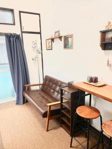 福冈FUEL INN的一张沙发,位于一个配有桌子和桌子的房间