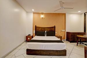 SaravliSuper OYO Flagship Hotel Golden Nest的一间卧室配有一张大床和一张桌子