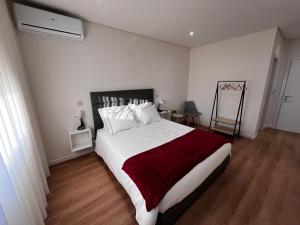 阿鲁卡Arouca Guest House 2的一间卧室配有一张带白色和红色床单的大床