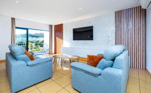 阿尔布费拉Apartamento Orada HotTub Billiard & Pool view的客厅配有2把蓝色椅子和电视