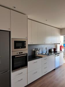 阿鲁卡Arouca Guest House 2的白色的厨房配有白色橱柜和电器