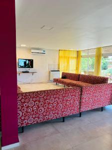 马德普拉塔GRAN HOTEL DE LOS ACANTILADOS的客房设有红色和白色的床以及平面电视。