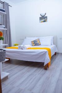 蒙巴萨Kezmo Siloam Paradise的一间卧室配有一张带橙色和白色毯子的床