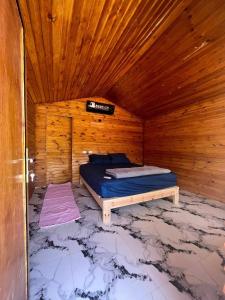 NuweibaFull Moon Camp Sinai的木制客房内的一间卧室,配有一张床
