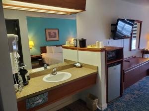 奥马克奥马克酒店的一间带水槽和镜子的浴室以及一张床