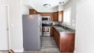 斯科茨Updated Condo in A Old Town Scottsdale Location的厨房配有木制橱柜和冰箱。