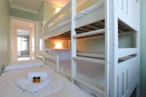 南海灵Amazing view High end beachfront 3BR 5beds 7 guest的一间卧室配有两张双层床、毛巾和蜡烛