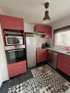 圣但尼Le Duplex Paris Basilique Stade de France的一间铺有瓷砖地板的红色橱柜厨房