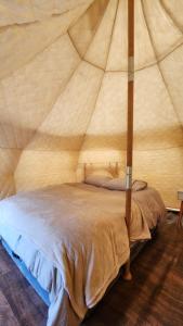 纳塔列斯港Glamping Río Serrano - Caja Los Andes的帐篷内一间卧室,配有一张床
