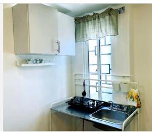 Ensanche Vista AlegreJC. Caribe Aparta Hotel…的一个带水槽和窗户的小厨房