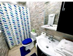 Ensanche Vista AlegreJC. Caribe Aparta Hotel…的浴室配有白色卫生间和盥洗盆。