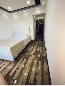 Ensanche Vista AlegreJC. Caribe Aparta Hotel…的一间卧室配有一张床,铺有木地板