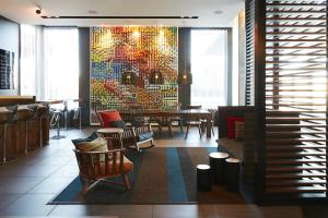 布罗瑟德阿尔特卡尔提尔DIX30酒店的一间带桌椅和马赛克墙的餐厅