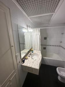 门多萨CASA BOMBAL的浴室配有盥洗盆、镜子和浴缸