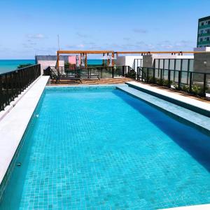 若昂佩索阿Eco Summer Tambaú - Apartamento de Alto Padrão de 2 Quartos的建筑物屋顶上的游泳池