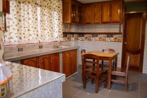 ConcepciónHOTEL CAMPO VERDE的厨房配有木制橱柜、桌子和水槽。