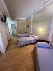 圣拉斐尔Soleado Apart Hotel的一间走廊上设有三张床的房间