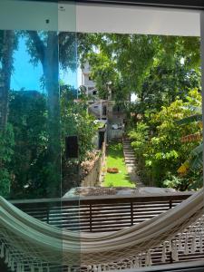 伊塔卡雷Pituba Ville - Ap - 1 andar - 2/4的享有花园景致的建筑内的吊床