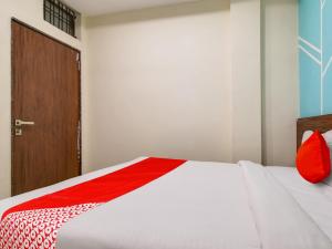 印多尔OYO Hotel 56 INDORI的一间有门的房间的一张红色和白色的床