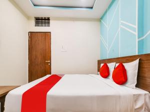 印多尔OYO Hotel 56 INDORI的一间卧室配有红色枕头的床