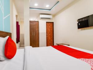 印多尔OYO Hotel 56 INDORI的卧室配有带红色枕头的白色床