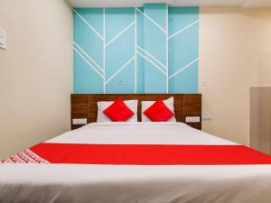 印多尔OYO Hotel 56 INDORI的一间卧室配有一张带红色枕头的大床