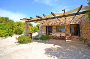 莱乌卡Villa La Pajara的庭院设有石头建筑和木制凉亭