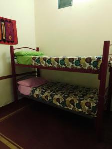 圣萨尔瓦多德朱HOSTEL JUJUY的配有长凳的小客房内的双层床