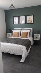 勒宝洛Le Brasil - Maison 74 m - Calme avec terrasse Sud classée 3 étoiles的卧室设有一张大床,拥有蓝色的墙壁