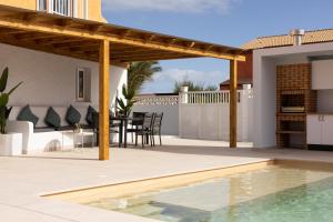 科拉雷侯Casa Nahia的一个带木制凉亭和游泳池的庭院