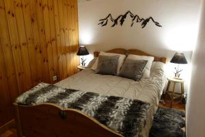 布里昂松Appartement cosy montagne, centre ville de Briançon的卧室配有一张挂有山 ⁇ 标志的床