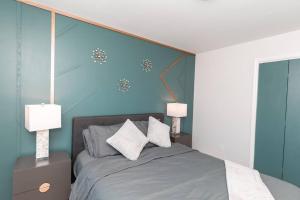 温泉城Carloover Vista: Mountain Escape的一间卧室配有一张带两盏灯的床。