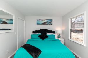 温泉城Carloover Vista: Mountain Escape的一间白色客房内的蓝色床卧室