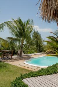 伊卡莱Villa Mango的一个带桌子和棕榈树的游泳池