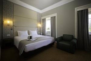里斯本麦拉帕奎酒店的配有一张床和一把椅子的酒店客房